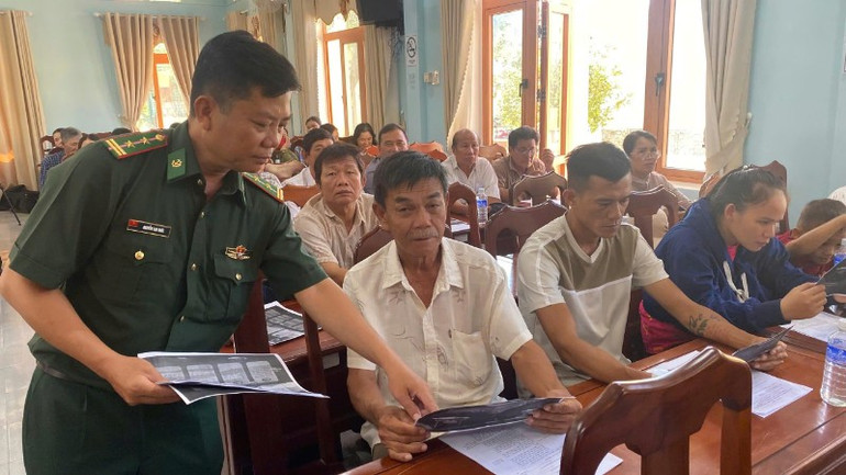 Cán bộ Đồn Biên phòng Cát Khánh phát tờ rơi tuyên truyền và hướng dẫn ngư dân quét mã QR. z6995614666661-42d49d7ed0b96412d2a840d3a9f38eb7-6237.jpg