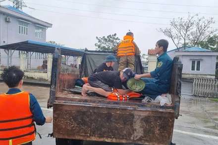 Lực lượng chức năng xã Điện Bàn Tây vận chuyển người bị nạn qua vùng ngập lũ để đi cấp cứu.