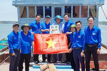 Trao tặng tủ thuốc và cờ Tổ quốc cho ngư dân.