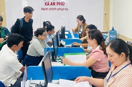 Cán bộ, viên chức xã An Phú hướng dẫn thủ tục hành chính cho người dân vùng biển Quảng Ngãi. (Ảnh ĐÔNG HUYỀN)