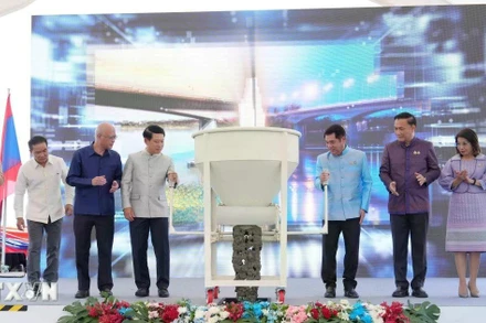 Phó Thủ tướng hai nước Lào-Thái Lan và đại diện các bộ, ngành hai nước thực hiện nghi thức đổ bê tông hợp long cầu. (Ảnh: XUÂN TÚ/TTXVN)