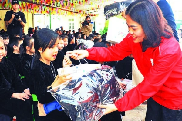 Lãnh đạo Hội Chữ thập đỏ trao quà cho các học sinh trên địa bàn. (Ảnh LƯƠNG THẢO)