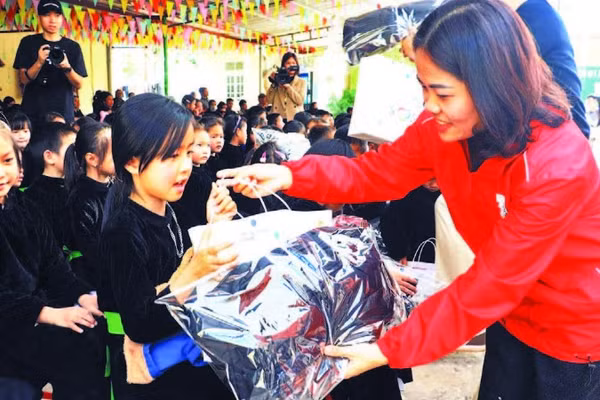Lãnh đạo Hội Chữ thập đỏ trao quà cho các học sinh trên địa bàn. (Ảnh LƯƠNG THẢO)