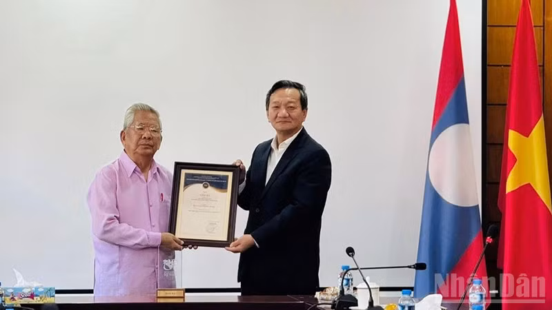 Đại sứ Nguyễn Minh Tâm trao Giải thưởng toàn quốc về Thông tin đối ngoại lần thứ XI-năm 2025 cho Nghệ sĩ quốc gia Lào, nhạc sĩ Duoangmixay Likaya. (Ảnh: DUY TOÀN)