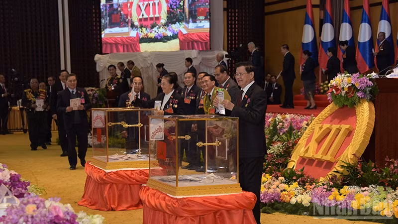 Tổng Bí thư, Chủ tịch nước Lào Thongloun Sisoulith và các đồng chí dự Đại hội bỏ phiếu bầu Ban Chấp hành Trung ương khóa mới. (Ảnh: TRỊNH DŨNG)