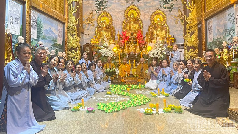 Cộng đồng người Việt Nam tại Lào thắp nến hoa đăng cầu nguyện cho đồng bào. (Ảnh: DUY TOÀN)