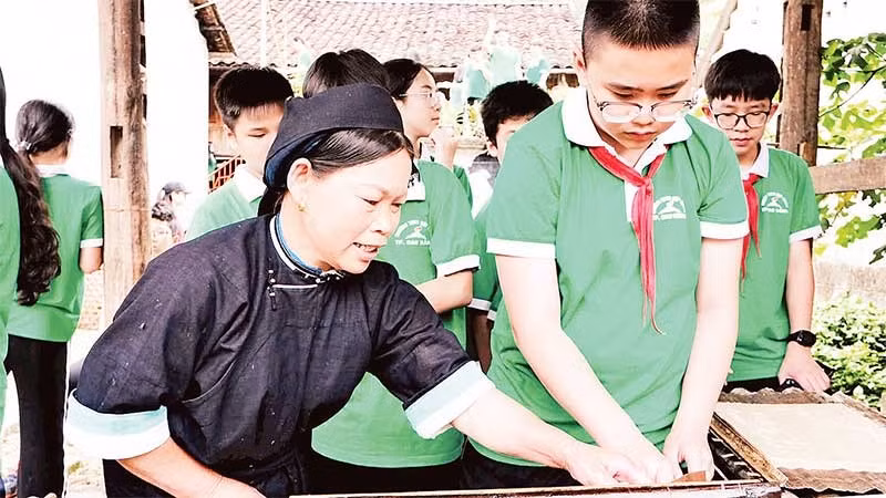Học sinh tham quan, trải nghiệm kỹ thuật làm giấy bản tại xóm Dìa Trên, xã Quảng Uyên.