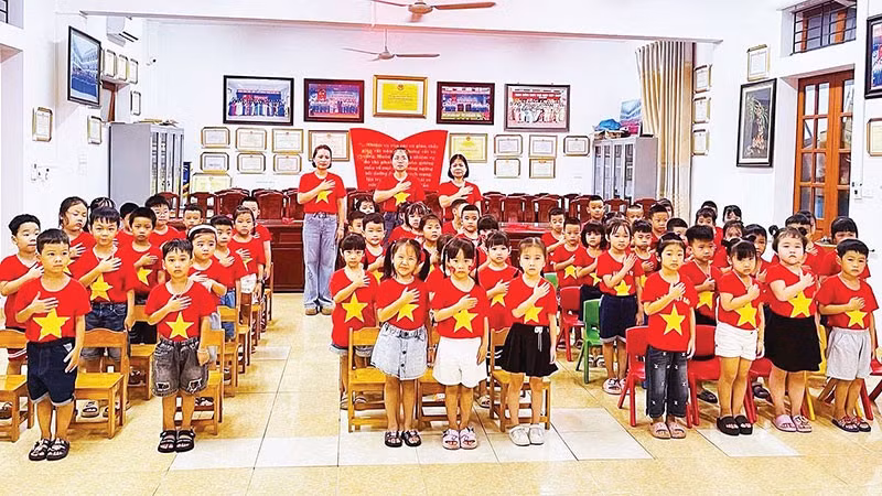 Cô và trò thực hiện nghi thức chào cờ trước khi vào chương trình xem phim về Quốc khánh 2/9.