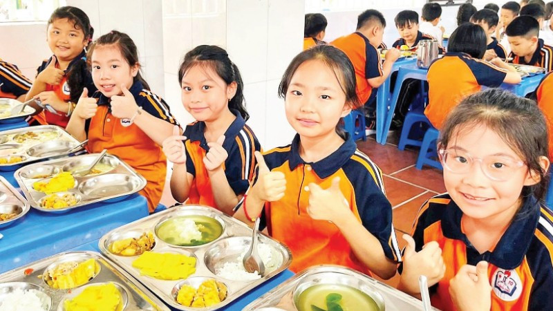 Giờ ăn bán trú của học sinh tại Trường tiểu học Thăng Long. (Ảnh NGỌC MINH)