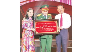 Đồng chí Nguyễn Văn Nên, Ủy viên Bộ Chính trị; Bí thư Thành ủy Thành phố Hồ Chí Minh trao bảng tôn vinh Đại tá, Anh hùng Lực lượng Vũ trang nhân dân Nguyễn Văn Tàu (Tư Cang).