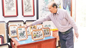 Nghệ nhân Nguyễn Hữu Hoa giới thiệu sản phẩm OCOP tranh dân gian Đông Hồ để bàn.