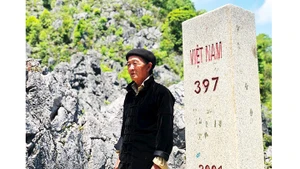 Ông Vù Chừ Lùng (thôn Lao Xa, xã Sủng Là, huyện Đồng Văn, Hà Giang) bên cột mốc biên giới gần nhà.