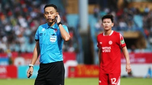 Trọng tài chính tham khảo trọng tài VAR trong một trận đấu tại V.League. Ảnh: LÊ MINH