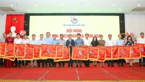 Chủ tịch Hội Nhà báo Việt Nam Lê Quốc Minh trao Cờ thi đua tặng tập thể có thành tích xuất sắc.