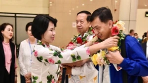 Phó Tổng cục trưởng Thể dục-Thể thao Lê Thị Hoàng Yến tặng hoa cho đại diện Đoàn rước đuốc Campuchia tại sân bay Nội Bài. (Ảnh: Tổng cục Thể dục-Thể thao).