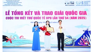 Minh Khuê (đứng giữa) nhận bằng khen và hoa trong lễ tổng kết và trao giải.