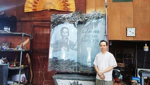 Nghệ nhân Bùi Minh Tự bên tác phẩm “Trang sử vàng”.