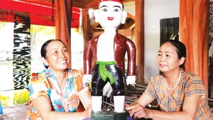 Nghệ nhân Ưu tú Nguyễn Thị Thỏa (bên trái) giới thiệu về rối nước Ðào Thục. 