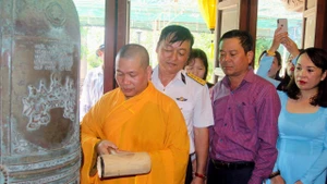 Thượng tọa Thích Giác Nghĩa cùng lãnh đạo Quân chủng Hải quân thỉnh chuông cầu nguyện cho các Anh hùng liệt sĩ tại đảo Sinh Tồn. Ảnh: Minh Tư