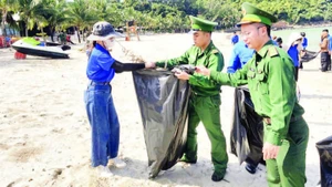 Cán bộ, chiến sĩ Biên phòng Cửa khẩu cảng Đà Nẵng cùng đoàn viên, thanh niên thành phố thu gom rác làm sạch bãi biển Đà Nẵng.