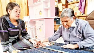 Nghệ nhân Ưu tú K’Glòng trao truyền nghề dệt thổ cẩm cho lớp trẻ.