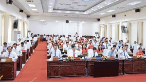 Đại biểu Hội đồng nhân dân tỉnh Cà Mau biểu quyết thông qua Nghị quyết về Đề án hợp nhất tỉnh Cà Mau và Bạc Liêu thành tỉnh Cà Mau.