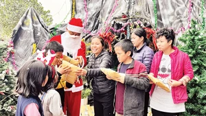 Một thành viên nhóm thiện nguyện đóng vai ông già Noel tặng quà Giáng sinh cho trẻ em ở mái ấm Thánh Tâm.