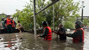Lực lượng dân quân hỗ trợ người dân di dời khỏi khu vực bị ngập đến nơi an toàn.