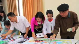 Nhóm tác giả sáng tác, hoàn thiện tranh truyền thông về bảo vệ phụ nữ, trẻ em.