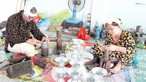Gia đình nghệ nhân Đàng Thị Mỹ Trâm chế tác sản phẩm do khách hàng đặt. 