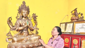 Nghệ nhân Bùi Thị Minh bên tác phẩm của gia đình.