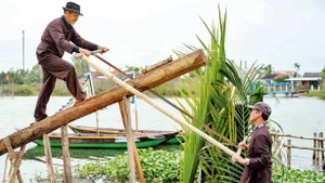 Nghệ nhân làng mộc Kim Bồng trình diễn nghi thức lấy gỗ làm mộc. 