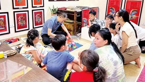 Nghệ nhân Ðào Ðình Chung giới thiệu kỹ thuật làm tranh cho các bạn nhỏ.