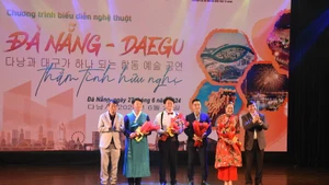 Ông Bùi Văn Tiếng, Chủ tịch Liên hiệp các Hội văn học nghệ thuật thành phố Đà Nẵng và Ông Lee Chang Hwan - Chủ tịch Liên hiệp các Hội Văn hóa nghệ thuật thành phố Daegu tặng hoa cho các nghệ sĩ. (Ảnh ANH ĐÀO)