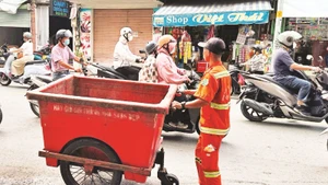Công nhân vệ sinh thu gom và vận chuyển rác thải ở Quận 1.