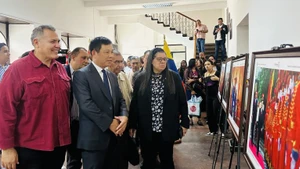Đại sứ Vũ Trung Mỹ và các đại biểu tham quan triển lãm ảnh Việt Nam-Hồ Chí Minh. (Ảnh: Đại sứ quán Việt Nam tại Venezuela)