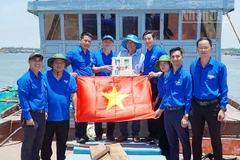 Trao tặng tủ thuốc và cờ Tổ quốc cho ngư dân.