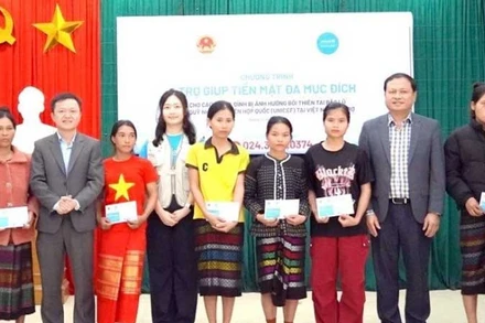 Các đại biểu trao trợ giúp tiền mặt tặng hộ gia đình bị ảnh hưởng thiên tai ở xã Kim Ngân, tỉnh Quảng Trị. (Ảnh NH)