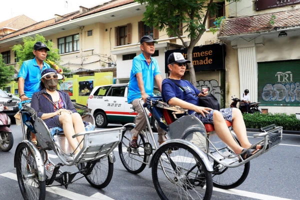 Du khách Nhật Bản khám phá trung tâm Thành phố Hồ Chí Minh bằng xích lô. (Ảnh: TTXVN)