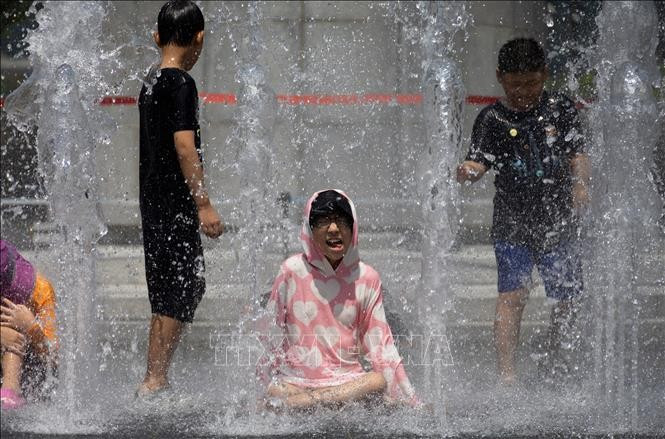 Các em nhỏ chơi đùa bên đài phun nước để tránh nóng tại Seoul, Hàn Quốc. (Ảnh: Yonhap/TTXVN) Các em nhỏ chơi đùa bên đài phun nước để tránh nóng tại Seoul, Hàn Quốc. (Ảnh: Yonhap/TTXVN)