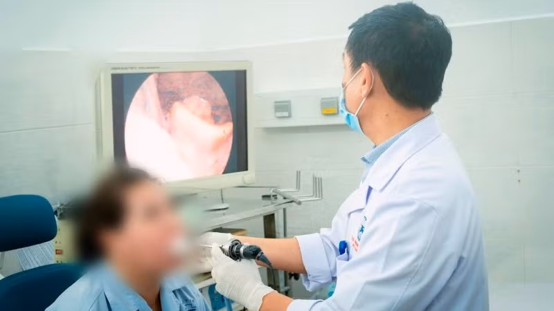 Bác sĩ nội soi thanh quản cho người bệnh sau thời gian điều trị.