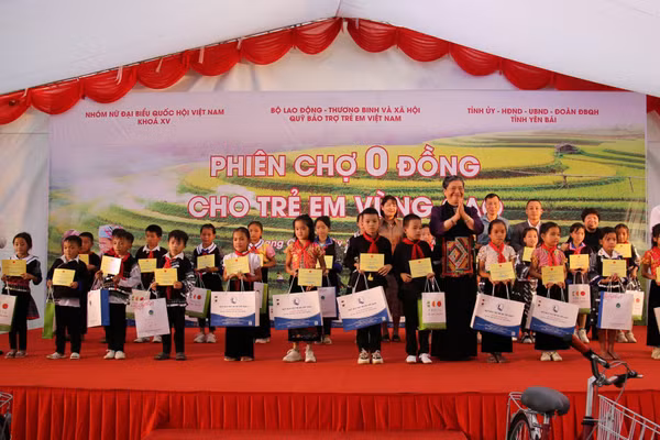 Các đại biểu trao học bổng và quà tặng các em học sinh trong “Phiên chợ 0 đồng”, tháng 9/2023, tại xã Cao Phạ, huyện Mù Cang Chải (cũ), tỉnh Yên Bái (trước đây). (Ảnh BTC)