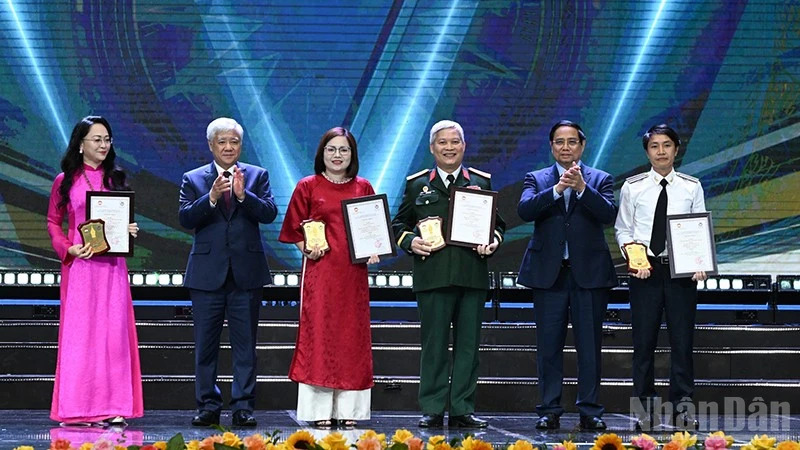Thủ tướng Phạm Minh Chính và Chủ tịch Ủy ban Trung ương Mặt trận Tổ quốc Việt Nam Đỗ Văn Chiến (lần lượt thứ 2 và 5 từ phải sang) trao giải A tặng các tác giả, đại diện nhóm tác giả. (Ảnh: TRẦN HẢI)