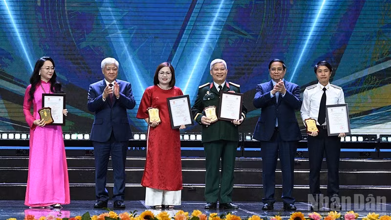 Thủ tướng Phạm Minh Chính và Chủ tịch Ủy ban Trung ương Mặt trận Tổ quốc Việt Nam Đỗ Văn Chiến (lần lượt thứ 2 và 5 từ phải sang) trao giải A tặng các tác giả, đại diện nhóm tác giả. (Ảnh: TRẦN HẢI)