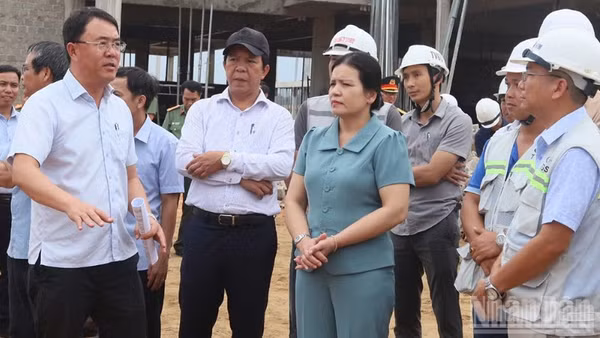 Giám đốc Ban Quản lý dự án đầu tư Tây Quảng Ngãi Võ Đại Tân (đứng bên trái) báo cáo tiến độ triển khai xây dựng trường nội trú liên cấp vùng biên.