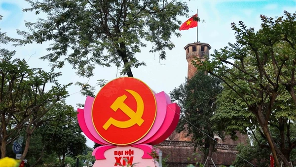 Biểu tượng búa liềm trên đài sen hồng nổi bật trước Cột cờ Hà Nội (khu vực đường Điện Biên Phủ), kết hợp vẻ đẹp lịch sử hào hùng với không khí chính trị trang nghiêm. (Ảnh: Vũ Quang/TTXVN)