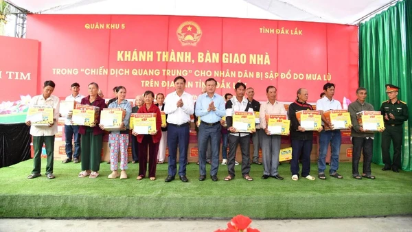 Các đồng chí lãnh đạo tỉnh Đắk Lắk bàn giao nhà trong "Chiến dịch Quang Trung" và tặng quà cho người dân vùng lũ.