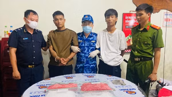 Hai đối tượng cùng tang vật trong vụ vận chuyển trái phép 18.000 viên hồng phiến và 2kg ma túy đá bị lực lượng chức năng bắt giữ.