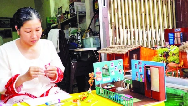 Chị Nguyễn Hồng Phúc cặm cụi từng chi tiết cho những mô hình “nhà xưa” thu nhỏ để lưu giữ ký ức tuổi thơ.