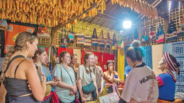 Du khách nước ngoài thích thú với những sản phẩm vải lanh của Lùng Tám. 